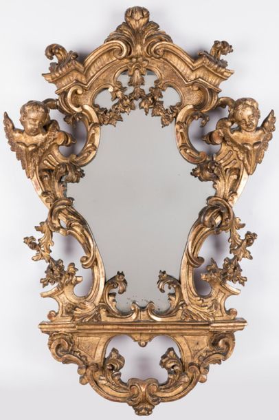 null Miroir en bois sculpté et doré de forme violonnée, le fronton architecturé,...