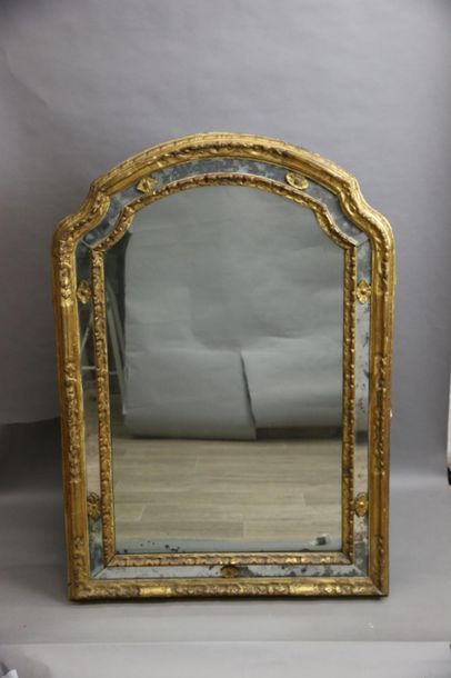 null Carved and gilded wood mirror, the curved pediment surmounted by an openwork...