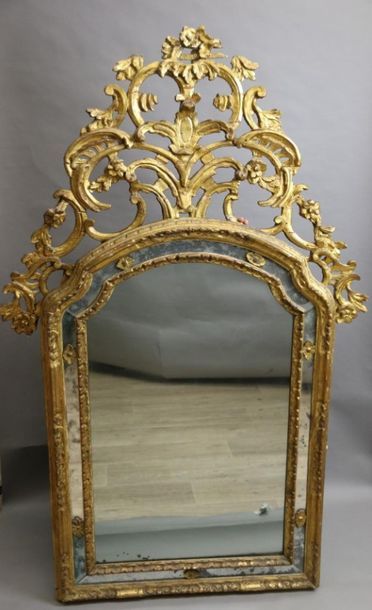 null Carved and gilded wood mirror, the curved pediment surmounted by an openwork...