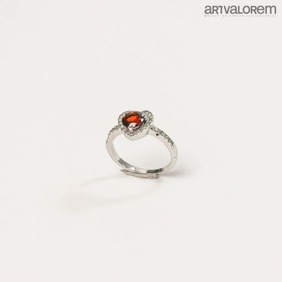 null 925°/°° silver ring centered on a round garnet in a heart-shaped frame set with...