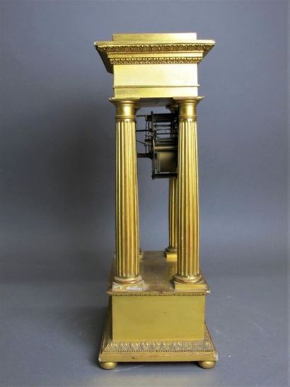 null Pendule portique en bronze et bois doré, le cadran émaillé blanc à index romains,...