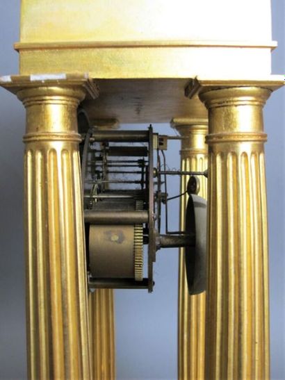 null Pendule portique en bronze et bois doré, le cadran émaillé blanc à index romains,...