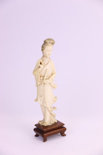 null Ivory statuette, young woman standing, a fan in her left hand, her pearl necklace...
