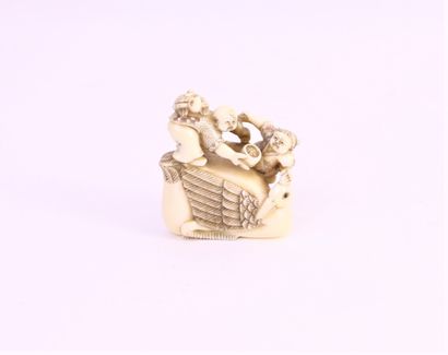 null Walrus ivory okimono, in the style of the netsuke, depicting two children perched...