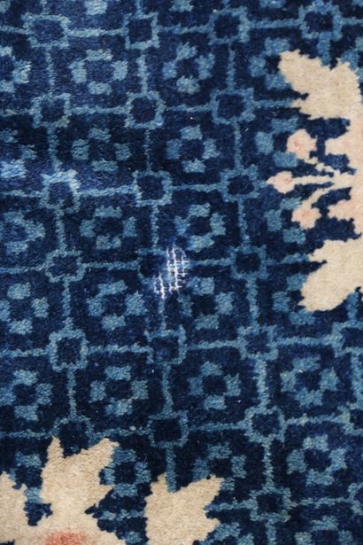  CHINE 
Tapis en laine à fond bleu marine à décor polychrome à semi de fleurs. 
154...