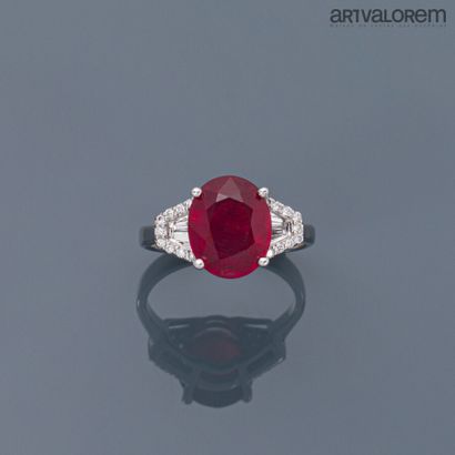 null Ring in white gold 750°/°° set with an oval faceted ruby and two tapers diamonds...