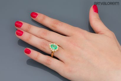null Yellow gold ring set with a pear-cut emerald in a setting of brilliant-cut diamonds...