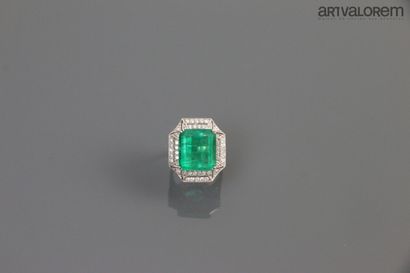 null A white gold ring centered on a Colombian emerald, rectangular shape with cut...
