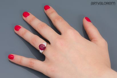 null Ring in white gold 750°/°° set with an oval faceted ruby and two tapers diamonds...