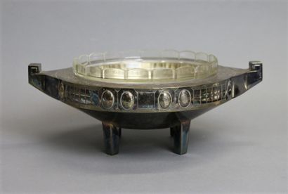 null A silver-plated metal and cut glass bowl resting on four straight legs with...