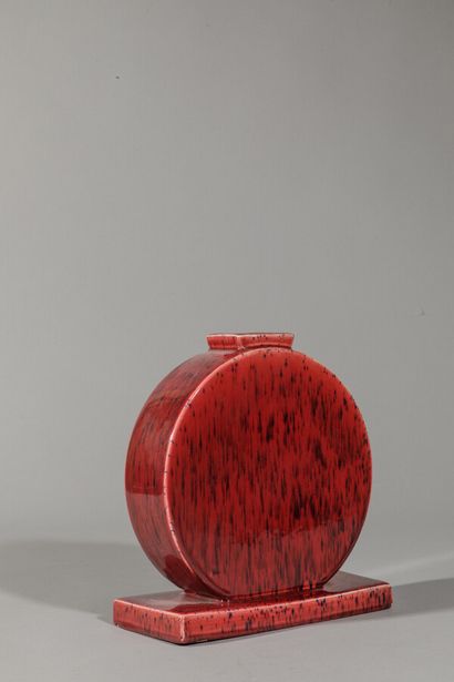 null Round flattened terracotta vase glazed in oxblood red with black drips.

Height:...