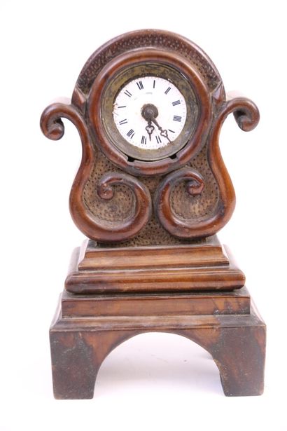 null Petite horloge en bois sculpté d'enroulements, cadran en émail blanc à index...