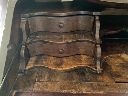 null Natural wood desk with a vase on the flap. It opens with three drawers in the...