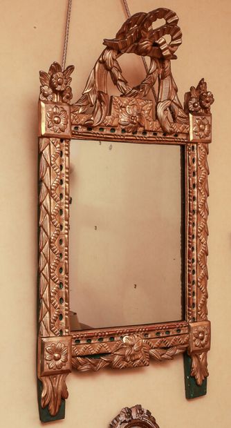 null Carved and gilded wood pediment mirror with a green background, decorated with...