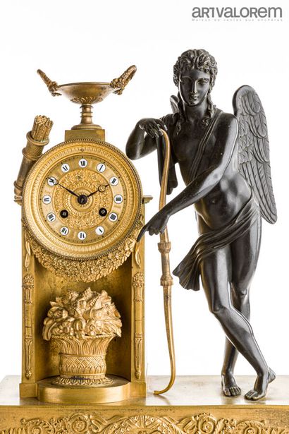 null Pendule en bronze doré et patiné, représentant Eros, accoudé au cadran, son...