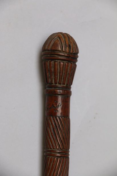 null Wooden cane entirely carved with stripes and mouldings, bearing an Arabic inscription....