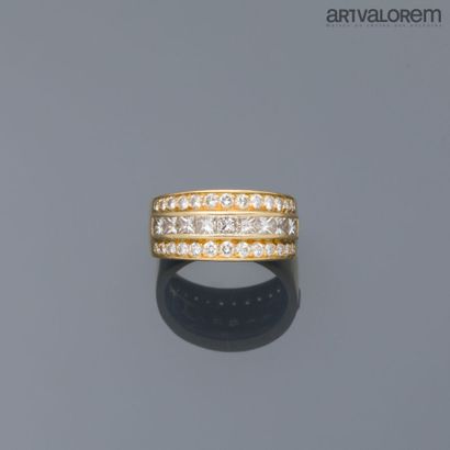 Yellow gold ring centered by a line of princess-cut...
