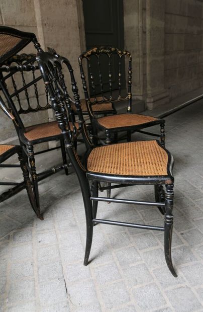 null Suite de huit chaises en bois noirci à décor doré de rinceaux feuillagés, dossier...