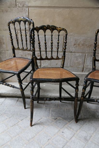 null Suite de huit chaises en bois noirci à décor doré de rinceaux feuillagés, dossier...