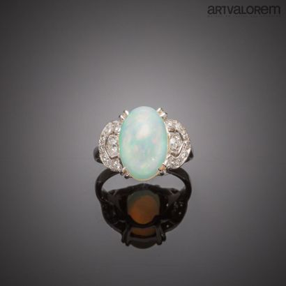 null Ring in white gold 750°/°° centered of an opal cabochon in double claw setting...