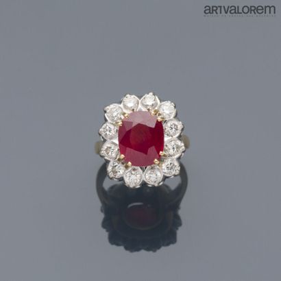null Yellow and white gold ring 750°/°° centered of a faceted oval ruby in a setting...