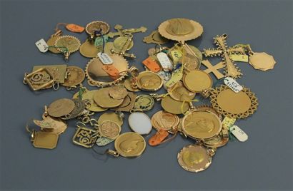 null Lot d'environ 57 médailles religieuses, souvenirs et croix en or 750°/°°. 

Poids...