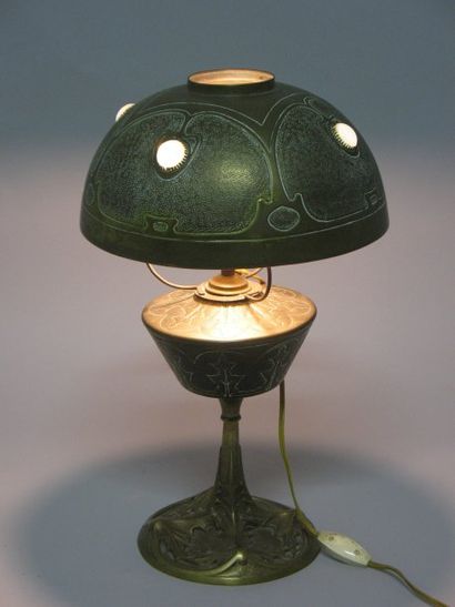 null Georges LELEU ; Lampe à pétrole éléctrifiée en bronze patiné à décor de chardons...