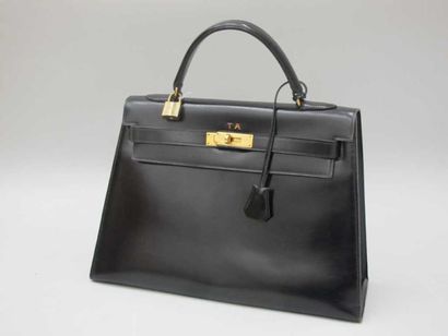 HERMES Sac Kelly en box noir, chiffré TA, clef, cadenas. Longueur: 33 cm. BE