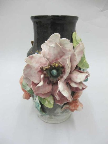 null Un vase ovoïde en barbotine à décor de roses sur un fond vernissé noir,marqué...