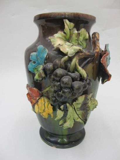 null Un vase balustre en barbotine, à décor de grappes de raisin et feuilles de vigne,...