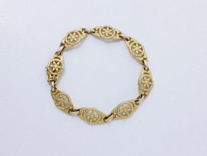 null Bracelet en or 18 K, composé de maillons ovales ajourés à décor floral et de...