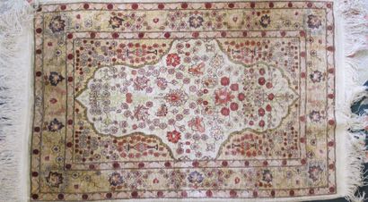 null TAPIS Fin Hereke (Turquie), vers 1975. Champ ivoire à semis de fleurs, en soie,...