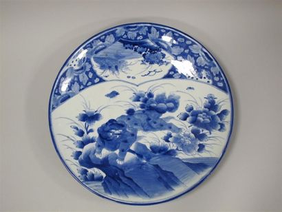 null JAPON, Epoque MEIJI (1868-1912). Plat en porcelaine bleu-blanc à décor de shishi....