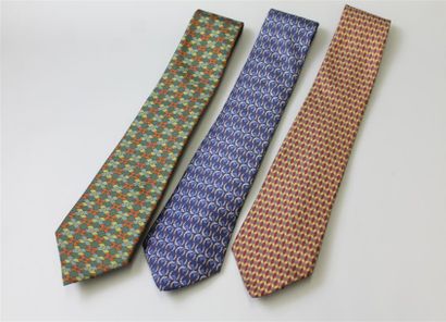 null HERMÈS. Ensemble de trois cravates, l'une bleue à motifs de fers à cheval gris...