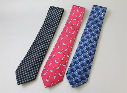null HERMÈS. Ensemble de trois cravates, l'une noire à motifs de carrés bleu clair...