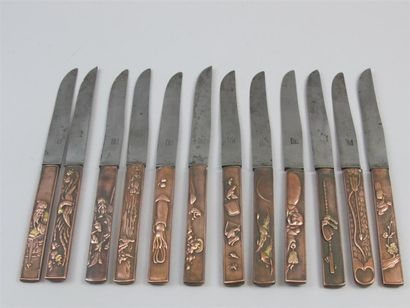 null Ensemble de 11 couteaux lame en métal et manche en cuivre orné sur chaque face...
