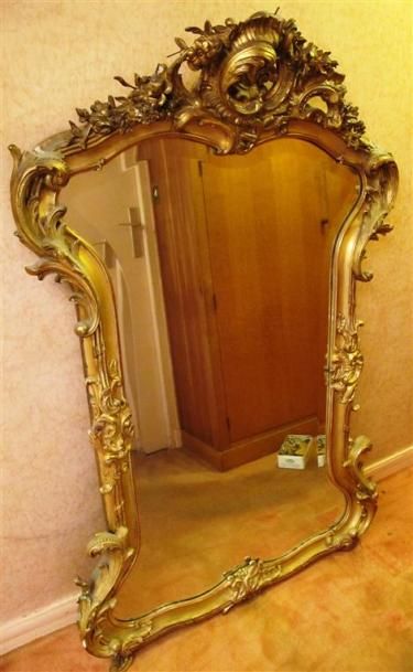 null Grand miroir en bois sculpté doré à décor de rinceaux et de coquilles, orné...