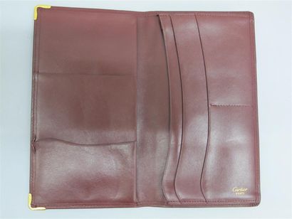 null CARTIER. Porte cartes en cuir bordeaux siglé. Dim. 19 x 10 cm. Avec sa boît...