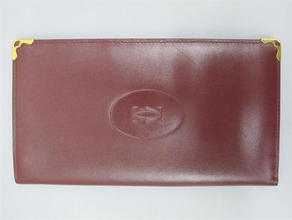 null CARTIER. Porte cartes en cuir bordeaux siglé. Dim. 19 x 10 cm. Avec sa boît...