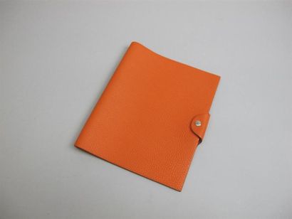  HERMES. Couverture d'agenda en taurillon orange modèle "Ulysse" , dim: 22,5 x 19...