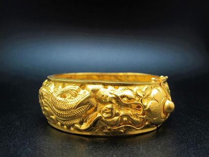 null Bracelet rigide en or jaune articulé à décor gravé d'un dragon et de phénix....