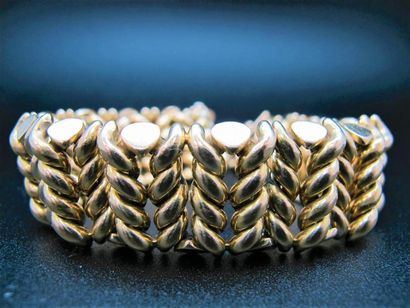 null CARTIER. Bracelet souple en or jaune 750°/°° (18k) à maille tressée de chevrons....