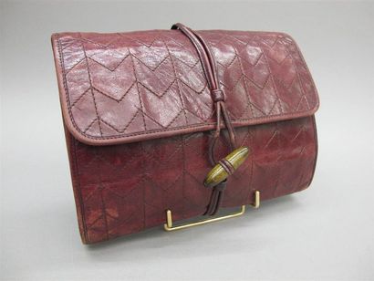 null YSL Paris. Pochette en cuir bordeaux à décor de chevrons, fermoir en olive de...