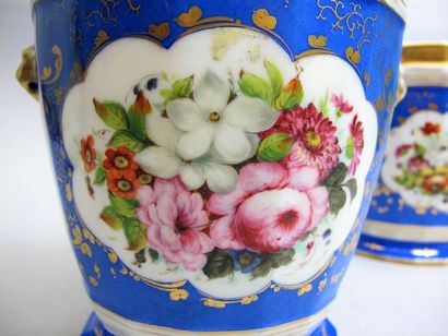 null PARIS. 
Paire de cache-pots en porcelaine à décor polychrome de bouquets de...