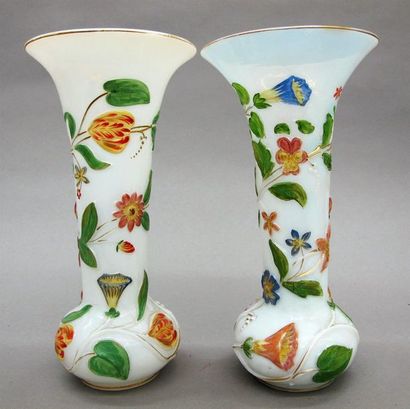 null Deux vases cornets en opaline blanche, à décor en relief de fleurs polychrome....