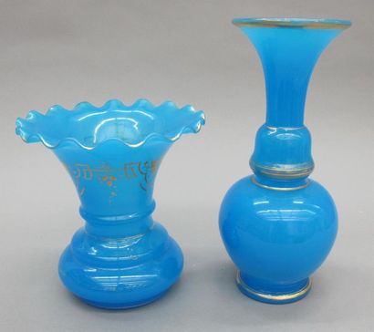 null Un vase en opaline bleue à long col à bord évasé à décor de filet or. 
H. 30...