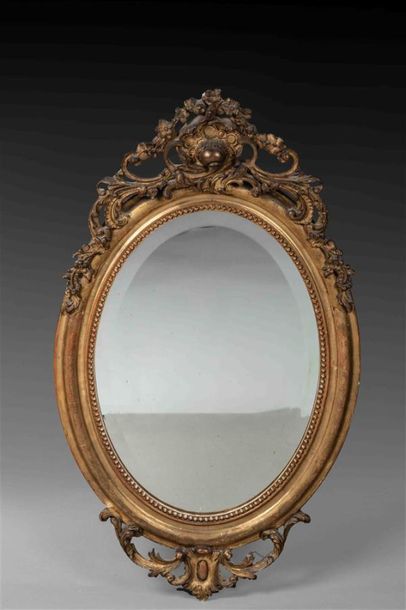 null Miroir ovale en bois et stuc dorés à décor de frise de perles sur le pourtour,...