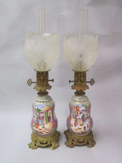 BAYEUX Paire de lampes à pétrole complètes en porcelaine à décor polychrome, dans...