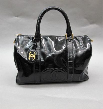 null CHANEL
Sac en cuir vernis noir, modèle " Boston", deux poches zippées intérieures.
L....