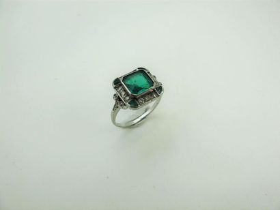 null Platinum ring decorated with a square cut emerald with cut sides and degrees...